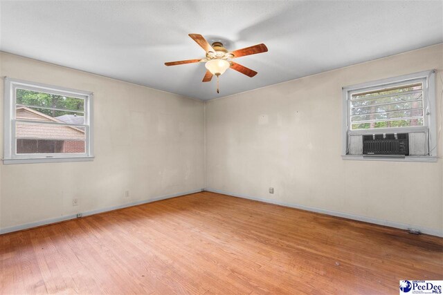 unfurnished room with baseboards, ceiling fan, wood finished floors, and cooling unit