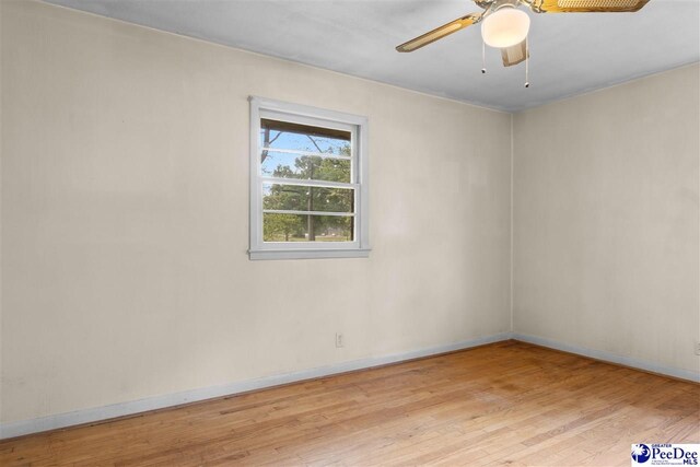 spare room featuring baseboards, a ceiling fan, and wood finished floors