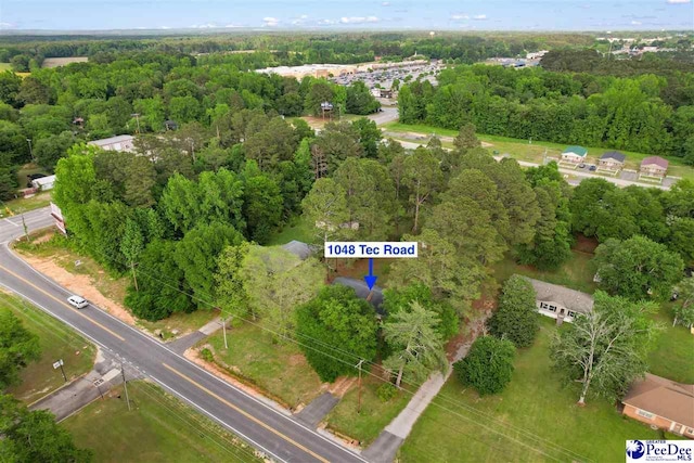 birds eye view of property featuring a wooded view