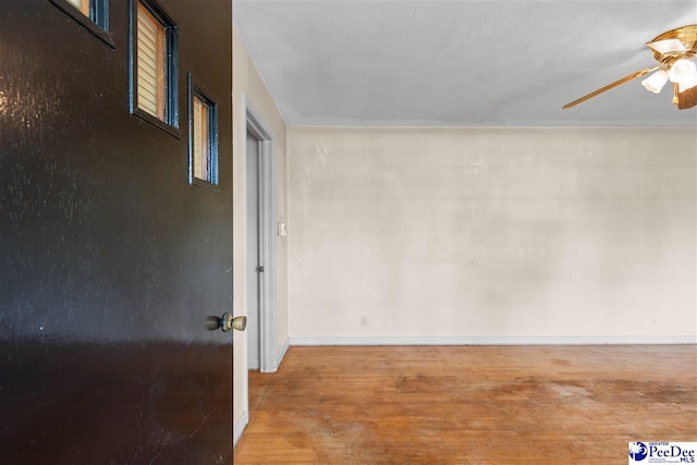 spare room with baseboards, a ceiling fan, and wood finished floors