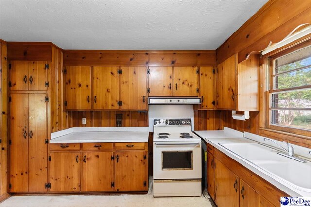 kitchen with exhaust hood, light countertops, brown cabinets, and white electric range