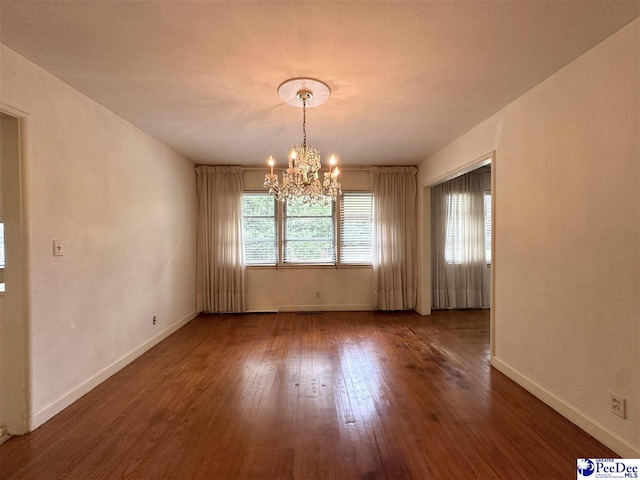 unfurnished dining area featuring dark wood-type flooring and a chandelier