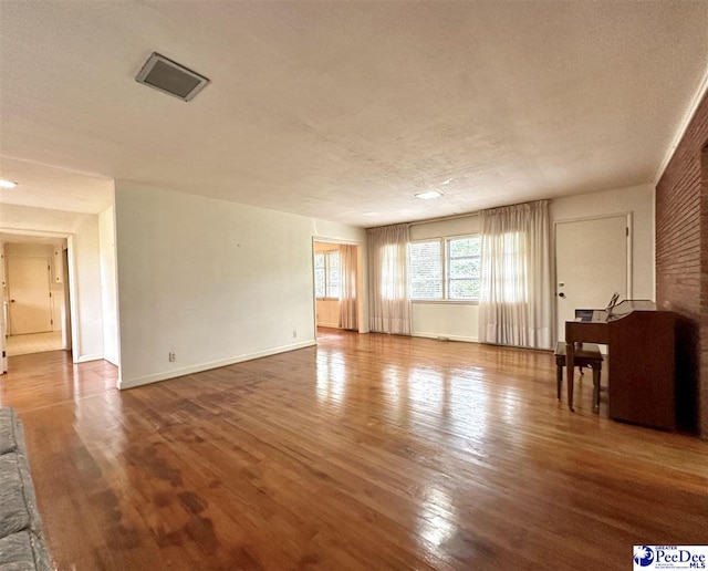 unfurnished living room featuring wood-type flooring and a textured ceiling