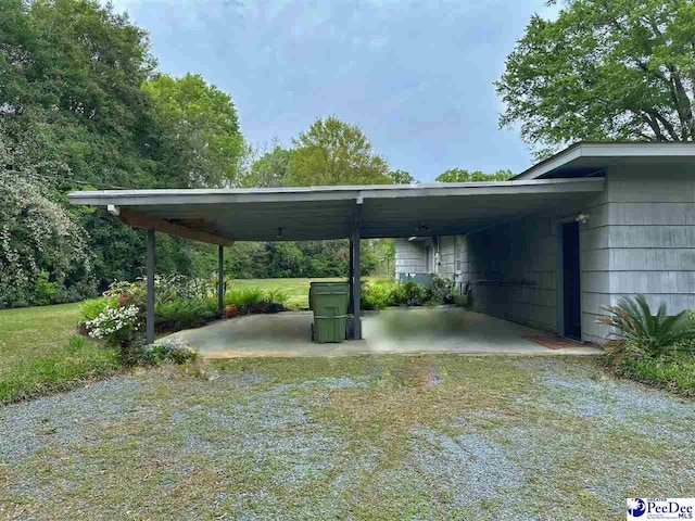 view of parking / parking lot featuring a carport and a lawn