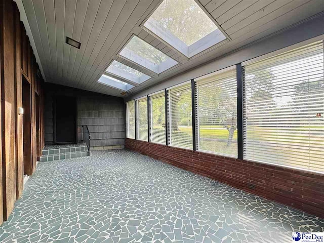 unfurnished sunroom with vaulted ceiling with skylight and wood ceiling