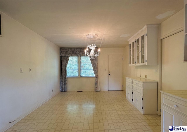 unfurnished dining area featuring a notable chandelier