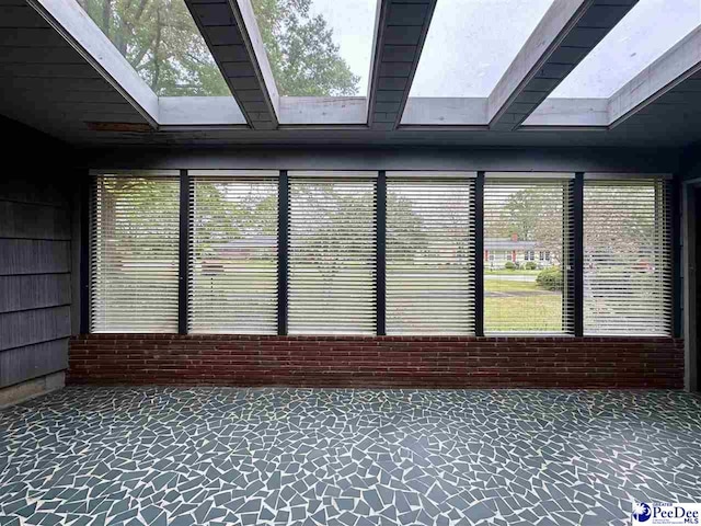 unfurnished sunroom with a skylight and plenty of natural light