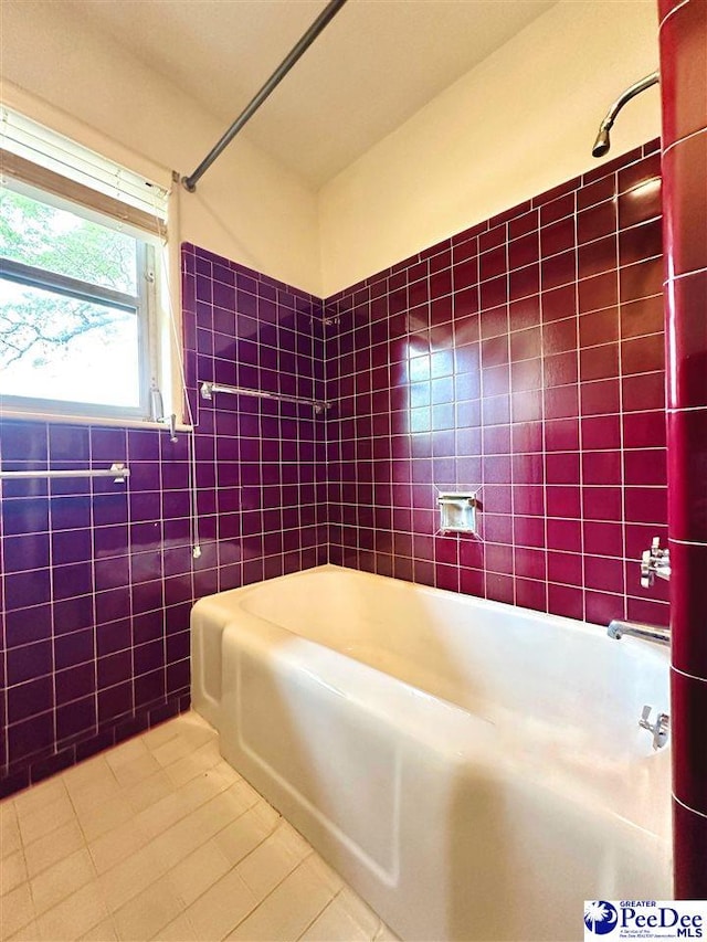 bathroom with tile patterned floors, shower / bathing tub combination, and tile walls