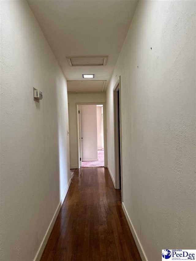 corridor with dark hardwood / wood-style flooring