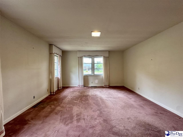 spare room featuring dark colored carpet