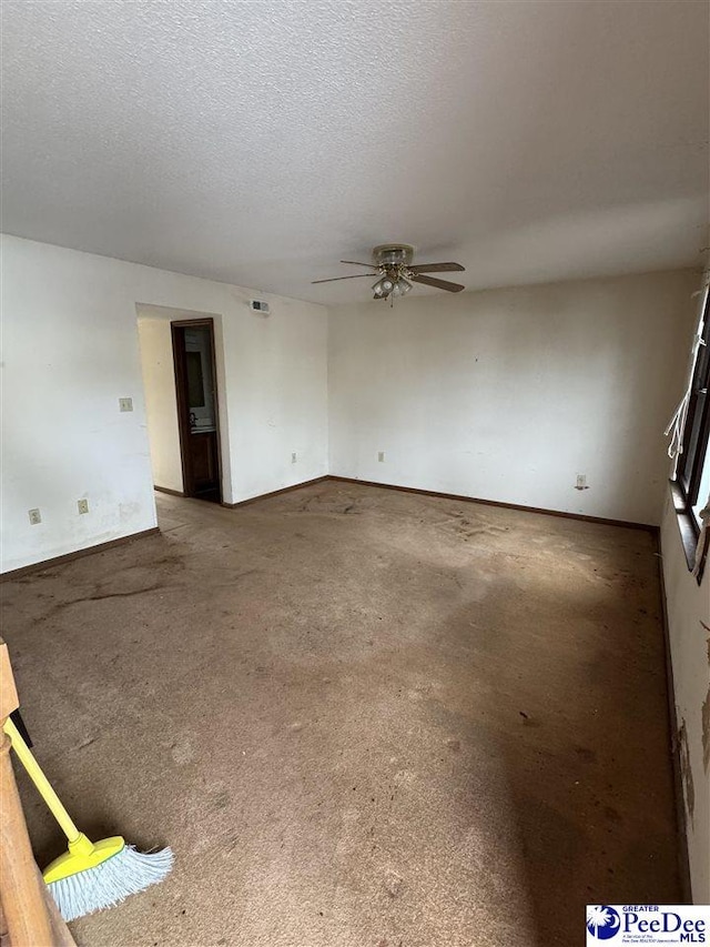 carpeted spare room featuring baseboards, a ceiling fan, visible vents, and a textured ceiling