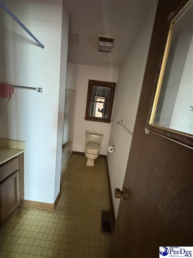 bathroom with visible vents, baseboards, toilet, and vanity