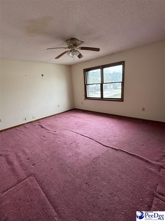 carpeted empty room featuring baseboards, a textured ceiling, and ceiling fan