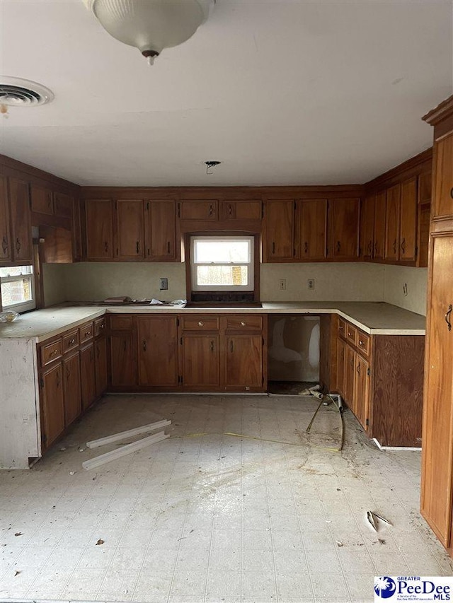 kitchen featuring dishwashing machine, light countertops, visible vents, and light floors