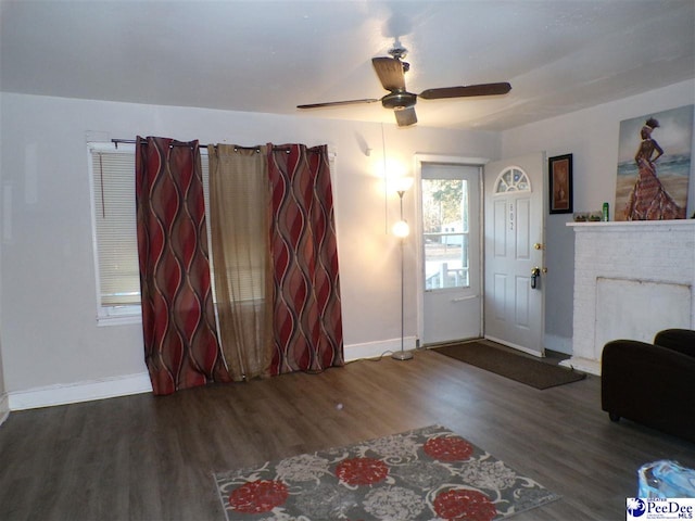 living room with dark wood-type flooring and ceiling fan