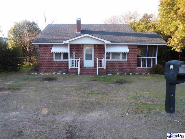 view of front of home featuring a sunroom and a front yard