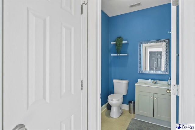 half bathroom featuring visible vents, toilet, vanity, tile patterned flooring, and baseboards