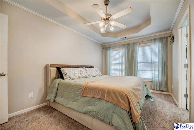 bedroom featuring light carpet, a tray ceiling, and baseboards