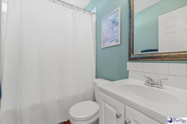 bathroom featuring a shower with curtain, vanity, and toilet