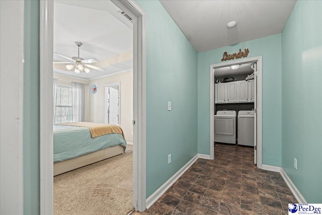 corridor featuring washing machine and dryer, stone finish floor, visible vents, and baseboards