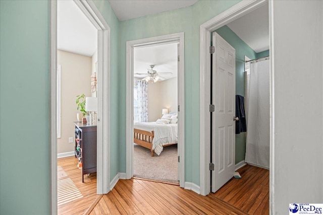 hallway with baseboards and wood finished floors