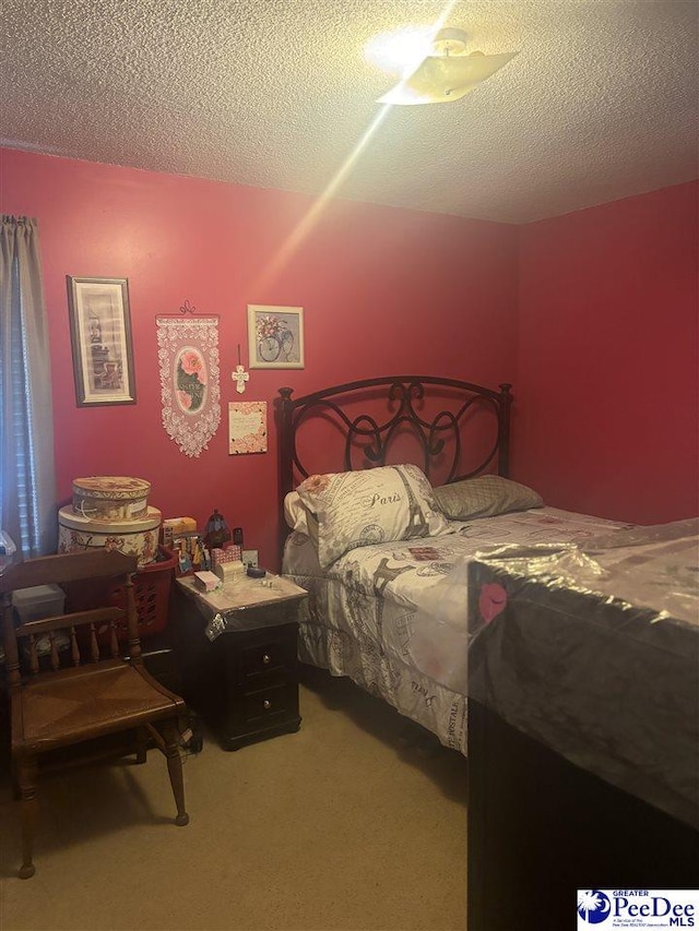 carpeted bedroom featuring a textured ceiling