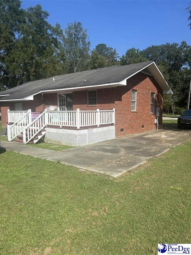 single story home with a deck and a front lawn