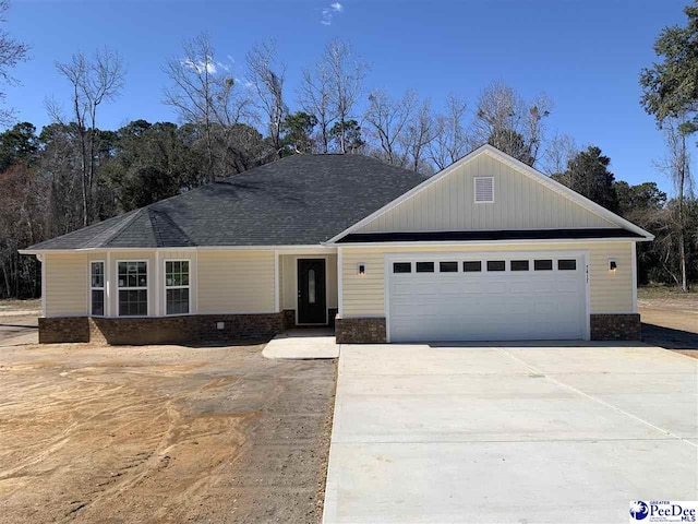 view of front of house with concrete driveway, an attached garage, and roof with shingles