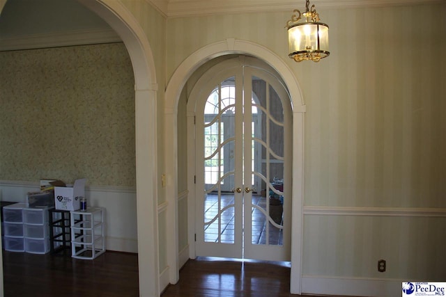 entryway with french doors, plenty of natural light, dark hardwood / wood-style flooring, and crown molding