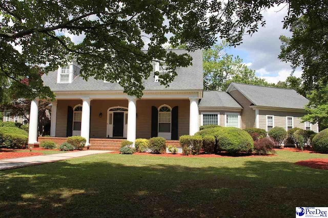 cape cod home featuring a porch and a front yard