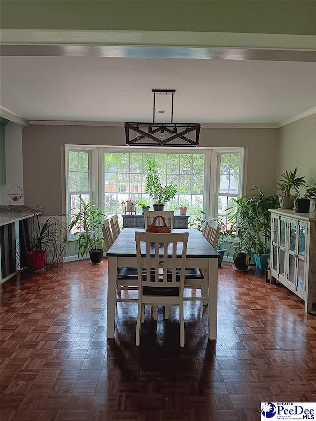 dining space featuring crown molding and dark parquet flooring