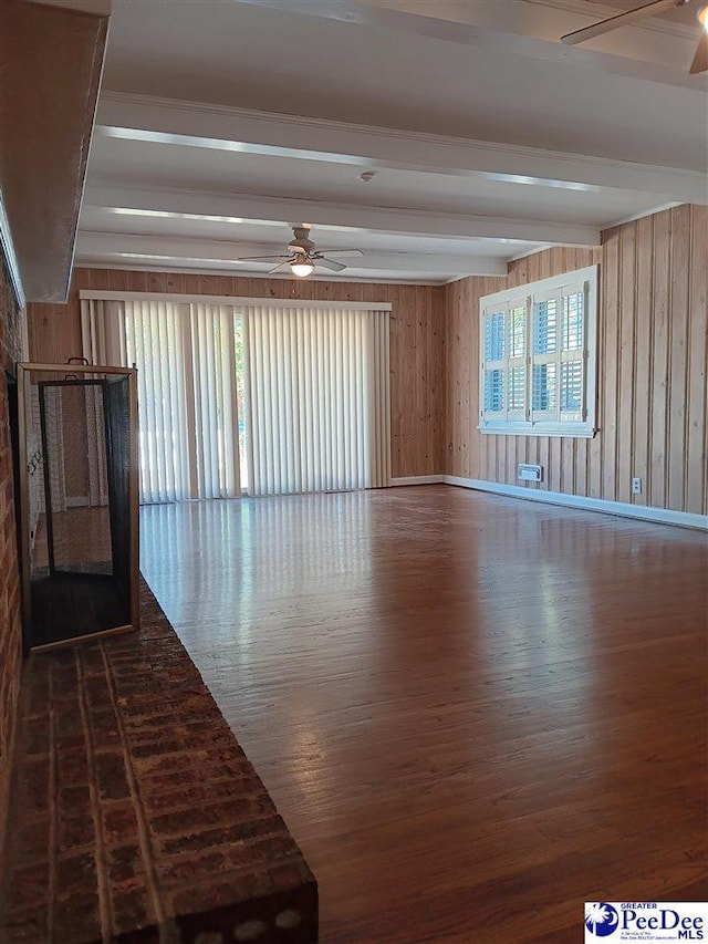 spare room featuring beamed ceiling, a healthy amount of sunlight, hardwood / wood-style floors, and ceiling fan