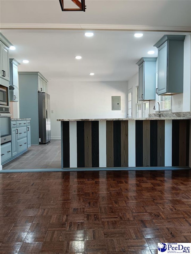 kitchen featuring appliances with stainless steel finishes, gray cabinetry, electric panel, and kitchen peninsula