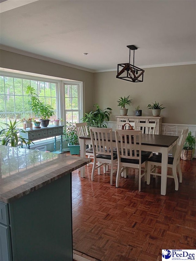 dining space with crown molding and dark parquet floors