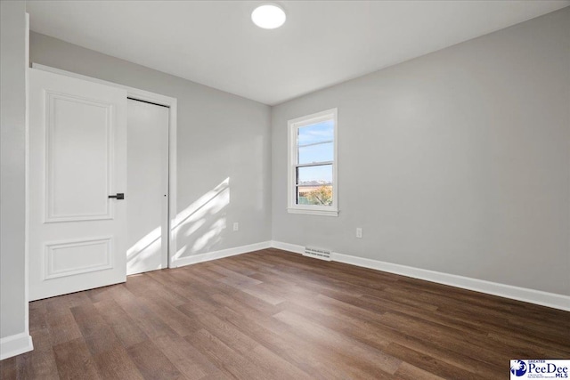 unfurnished bedroom featuring hardwood / wood-style floors and a closet