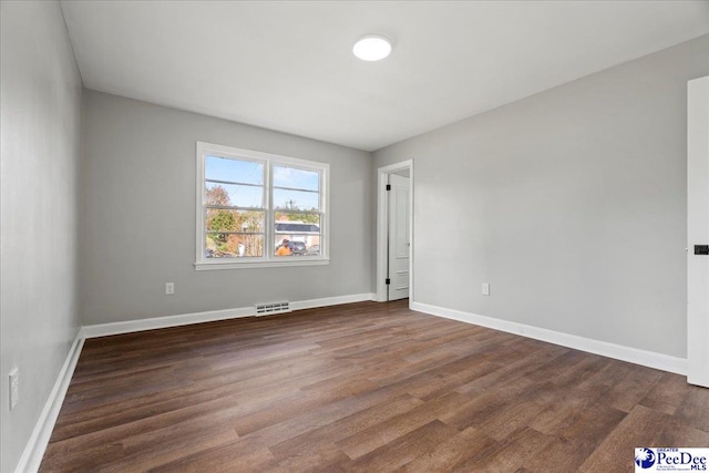 unfurnished room with dark hardwood / wood-style flooring