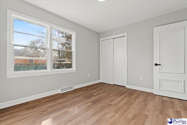 unfurnished bedroom featuring a closet and light wood-type flooring