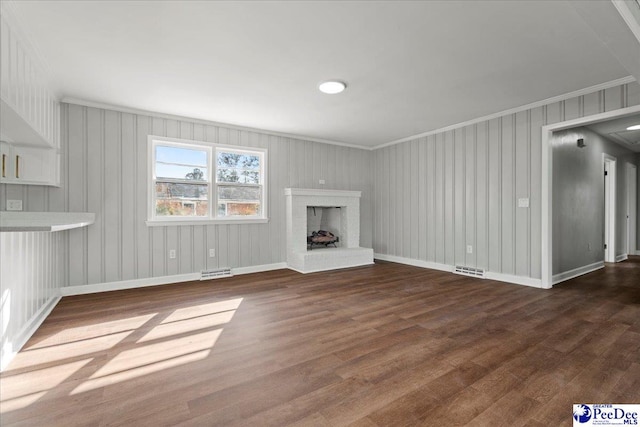 unfurnished living room featuring crown molding, dark wood-type flooring, and a fireplace