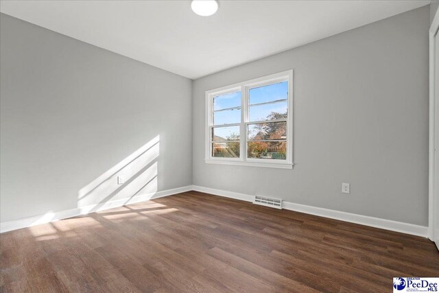 spare room featuring dark wood-type flooring