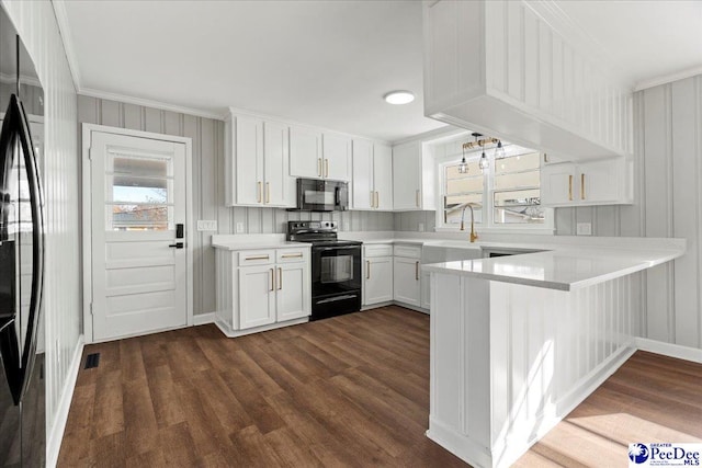 kitchen featuring sink, white cabinetry, dark hardwood / wood-style flooring, kitchen peninsula, and black appliances