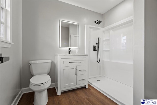 bathroom with vanity, toilet, hardwood / wood-style floors, and a shower