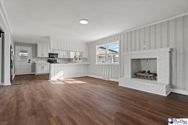 unfurnished living room with dark hardwood / wood-style flooring, sink, crown molding, and a fireplace