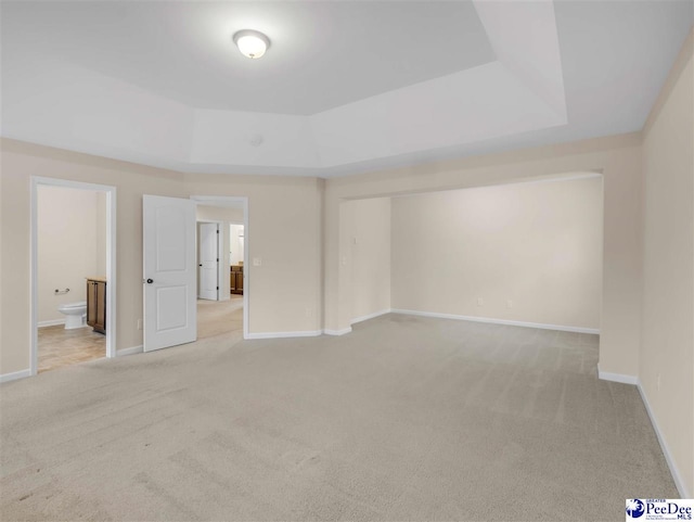 carpeted empty room featuring a tray ceiling