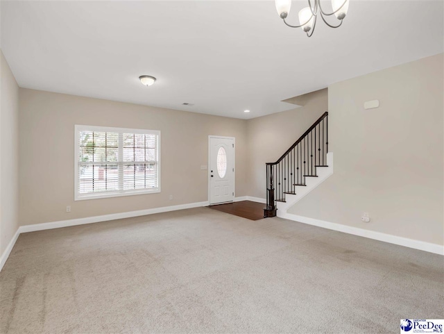 carpeted entryway with an inviting chandelier