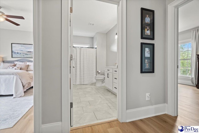 corridor featuring baseboards and light wood-type flooring