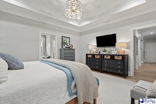 bedroom with baseboards, crown molding, a notable chandelier, and wood finished floors