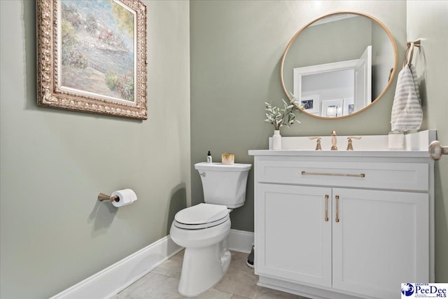 bathroom with toilet, vanity, and baseboards