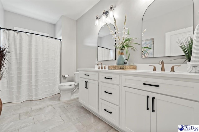 bathroom featuring double vanity, a sink, toilet, and a shower with curtain