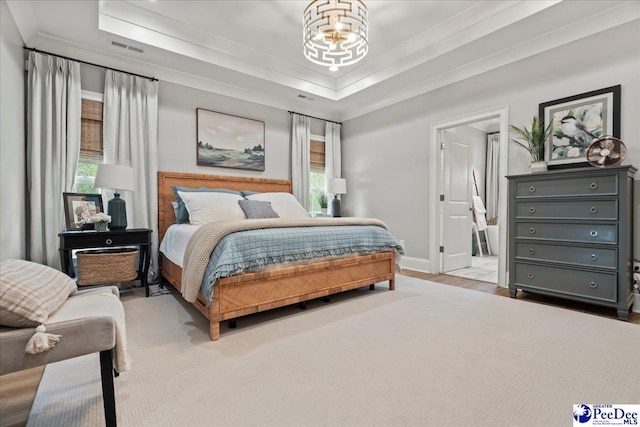 bedroom with a notable chandelier, a tray ceiling, multiple windows, and visible vents