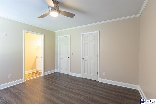 unfurnished bedroom featuring dark wood-type flooring, ceiling fan, ensuite bathroom, and crown molding